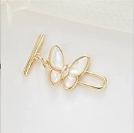 Detail of 14K gold plated butterfly toggle clasp featuring white shell inlay and center crystal