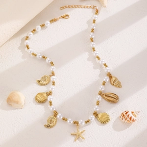 Detailansicht der Boho-Halskette mit goldenen Seesternen, Muscheln und weißen Perlen