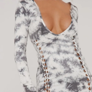 Détail d'une robe en maille tie-dye avec découpes latérales à lacets et coupe ajustée
