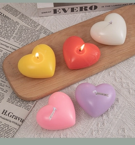 Colorful heart-shaped scented candles arranged on a wooden tray for home decor