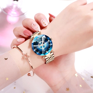 Detailed macro view of faceted glass crystal on rose gold watch with sparkling blue dial