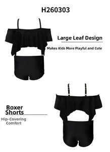 Detail of girls black two-piece swimsuit with ruffle off-shoulder top and boy-leg bottoms