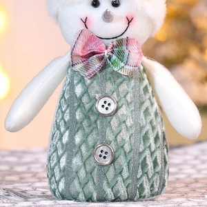 Detail einer Plüsch-Schneemann-Puppe mit Stricktextur und silbernen Knopfverzierungen