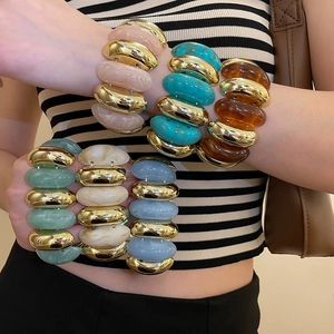 Detail of colorful marble acrylic oval link bracelets with golden metal accents