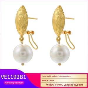 Detail of vintage brass pearl earrings with textured gold finish and large white pearls