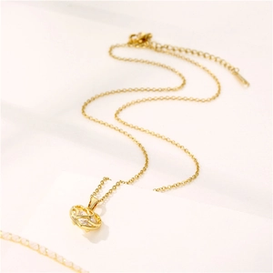 Collier élégant en or avec pendentif coeur évidé et pierre de zircon sur fond blanc