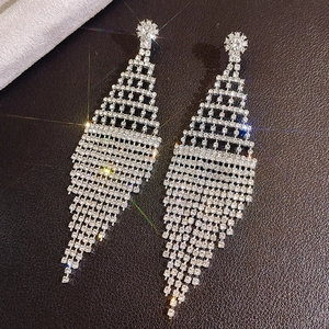 Macro shot of silver rhinestone tassel earrings featuring a cascading diamond fringe design