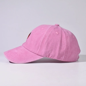 Vista laterale dettagliata di un berretto da baseball rosa con ricamo a forma di fragola.