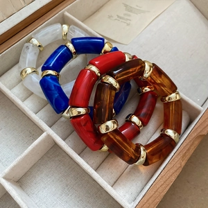 Detail view of four-piece resin bracelets with gold spacers and marbled texture finish