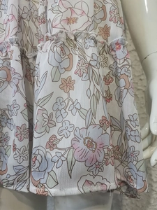 Macro view of floral chiffon fabric with ruffles on a dress showing texture and stitching
