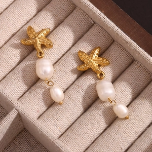 Vintage 18K gold-plated starfish and double pearl drop earrings on a jewelry box