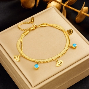 Double-layered gold chain bracelet with blue evil eye bead and stainless steel charms