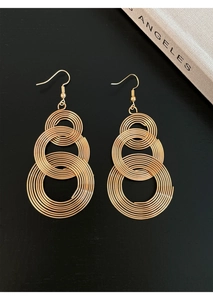 Macro view of multi-layered golden circular hollow tassel drop earrings with spiral texture
