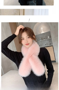 Close-up of fluffy pink faux fur scarf with dense texture worn over black knit sweater