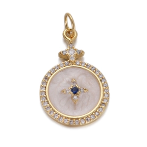 Detailed macro view of a gold-plated charm with white mother-of-pearl and blue gemstone