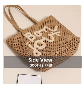 Detail shot of woven tote bag showing side width and white letter embroidery
