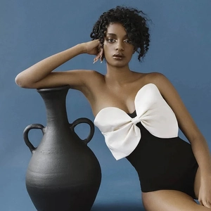 Détail d'un élégant maillot de bain noir à une épaule avec un grand nœud décoratif blanc