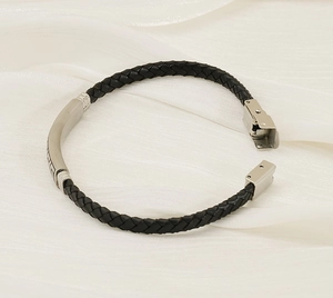 Nahaufnahme eines geflochtenen schwarzen Lederarmbands mit gebürstetem Stahlverschluss