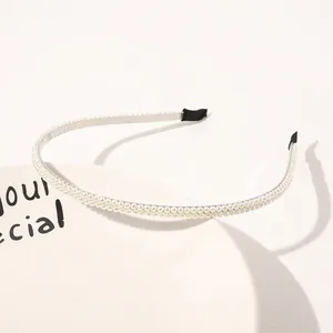 Close-up detail of double-row white pearl headband with protective black ends