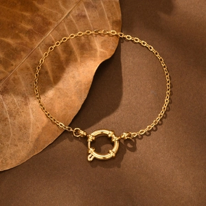 Detailed shot of golden flat cross chain bracelet with large round bubble buckle clasp