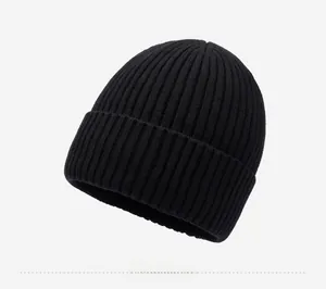 Detail of black ribbed knit beanie featuring a silver mountain logo on the folded cuff