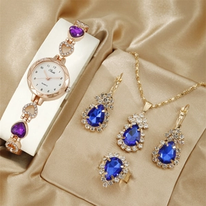 Luxury gold women's watch set with blue teardrop necklace, earrings and ring on satin