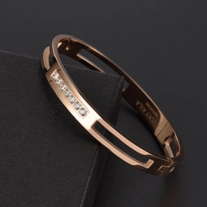 Bracelet ajouré en acier titane or rose avec zircons sertis sur fond en cuir noir