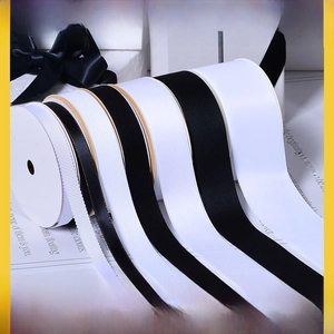 Detail of assorted black and white ribbons with gold edges and various textures