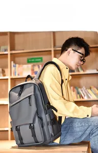 Man wearing a grey multi-compartment functional backpack in a library setting