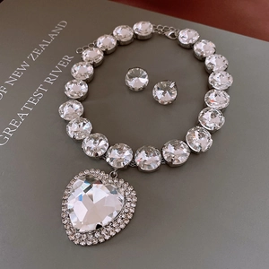 Detailed close-up of heart-shaped rhinestone pendant necklace and matching stud earrings