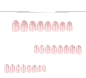 Flat lay of pink gradient press-on nails with silver glitter and delicate floral motifs