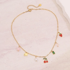 Dettaglio collana dorata con ciliegia smaltata, fragola e accenti di perle d'acqua dolce