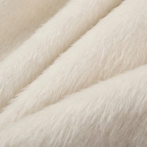 Macro view showing the soft texture and fiber detail of white faux fur blazer fabric