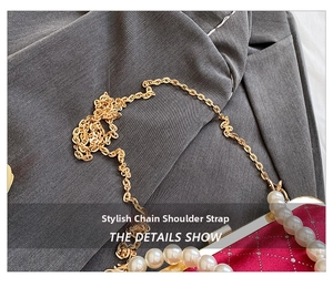 Detail of red velvet bag with pearl embellishments and elegant golden chain strap