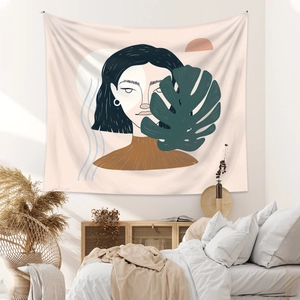 Abstract female portrait tapestry with monstera leaf in a warm bohemian bedroom setting