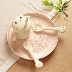 Silicone baby dinnerware set featuring cat-shaped cup and utensils on a dining table