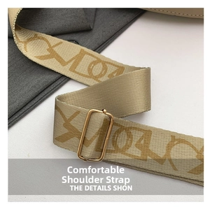 Close-up of wide jacquard shoulder strap with golden metal buckle on a luxury saddle bag