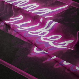 Detail of soft fabric texture with purple neon artistic typography on black tapestry
