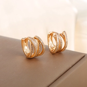Macro shot of gold-plated geometric hoop earrings with layered pavé cubic zirconia