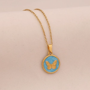Detail of round gold pendant with light blue enamel and embossed golden butterfly