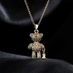 Gold bear pendant necklace with colorful micro-pave zircons on black silk background