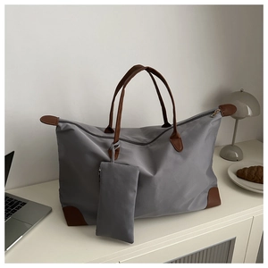 Detail of grey waterproof nylon tote bag with brown leather straps and inner pouch