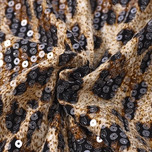 Macro shot of sequined leopard print fabric with shimmering circular sequins detail