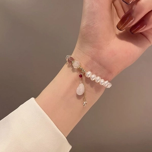 Detailed close-up of Baroque pearl bracelet with pink crystals on woman's wrist