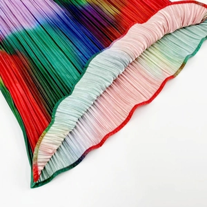 Macro detail of rainbow gradient pleated fabric with vertical texture on maxi dress