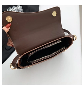 Detail view of large dark brown crossbody bag showing interior compartments and gold zipper