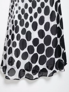 Detail of black and white Dalmatian polka dot print on flowing dress fabric