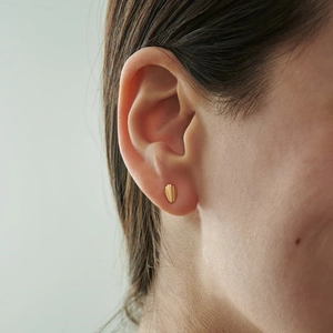 Elegant gold shell stud earrings with vintage texture on model ear for women
