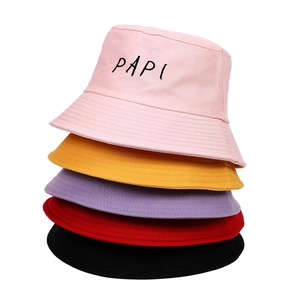 Detail showing five stacked colorful cotton bucket hats with PAPI embroidered letters
