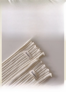 Detailed macro view of white ribbed cotton socks with ruffled edges and fabric label